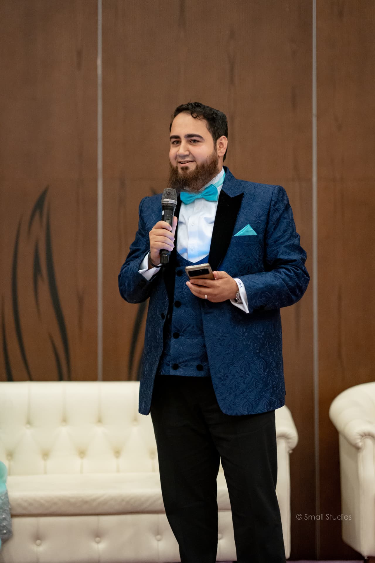 Huzefa Vorajee, Founder and CEO of Evolve Accounting Group, speaking on stage with a microphone in a navy tuxedo jacket